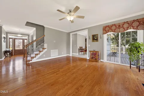 an empty room with windows fireplace and wooden floor