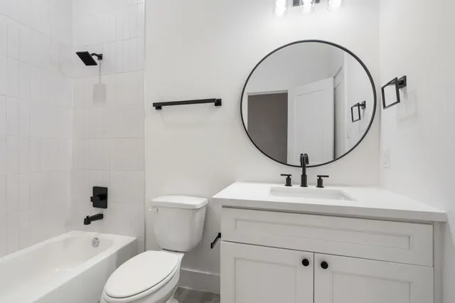 a bathroom with a sink a toilet and a mirror