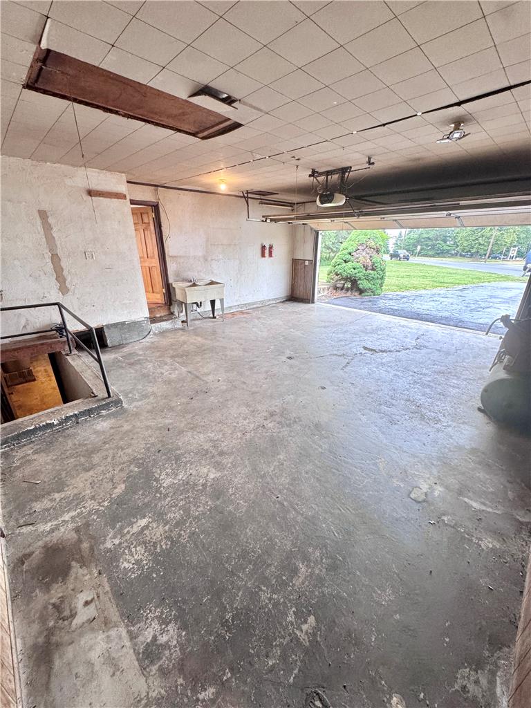 8325 Schantz Road Breinigsville, PA 18031 - Photo 17 of 21 A spacious, bare garage awaits transformation, featuring a basement entry and overhead door access.