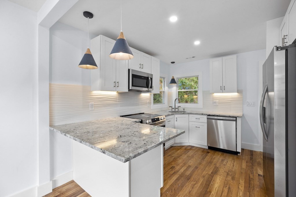 256 Great Road Maynard, MA 01754 - Photo 2 of 26 a kitchen with kitchen island granite countertop a sink appliances and cabinets