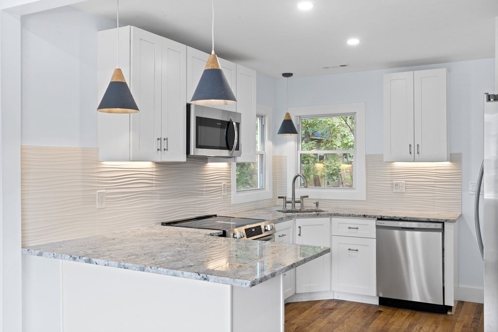 256 Great Road Maynard, MA 01754 - Photo 5 of 26 a kitchen with granite countertop a sink a stove and cabinets