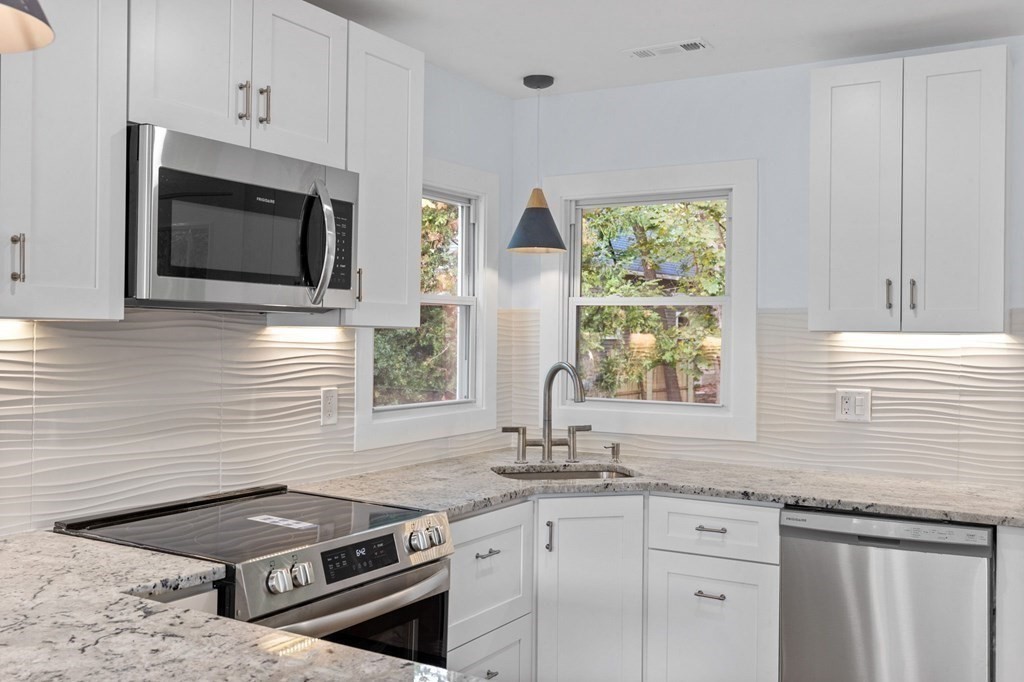 256 Great Road Maynard, MA 01754 - Photo 6 of 26 a kitchen with stainless steel appliances granite countertop a stove a sink and a microwave