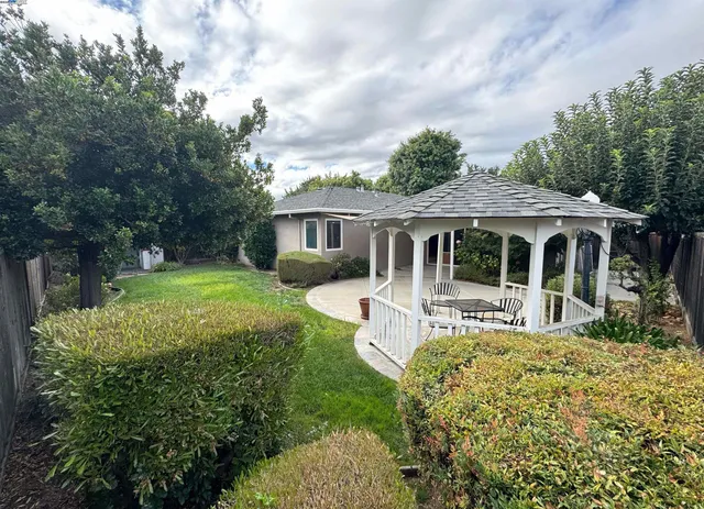 a house view with a garden space and wooden fence
