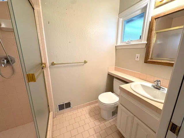 a bathroom with a sink a toilet and a mirror