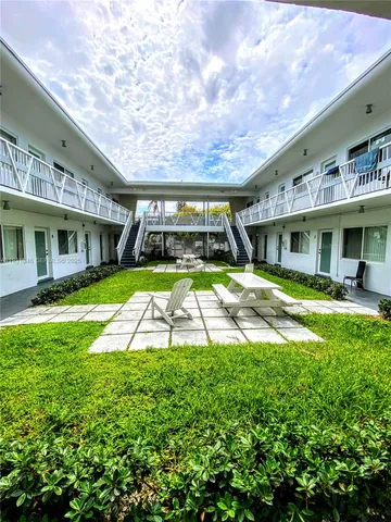 a view of a house with a big yard and potted plants