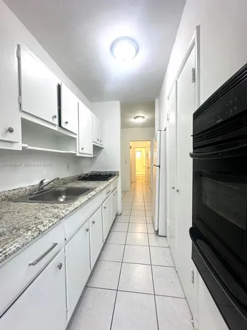 a large kitchen with stainless steel appliances granite countertop a stove and a sink