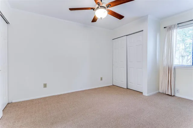 an empty room with closet and windows