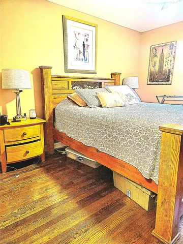 a bedroom with a bed and painting on the wall