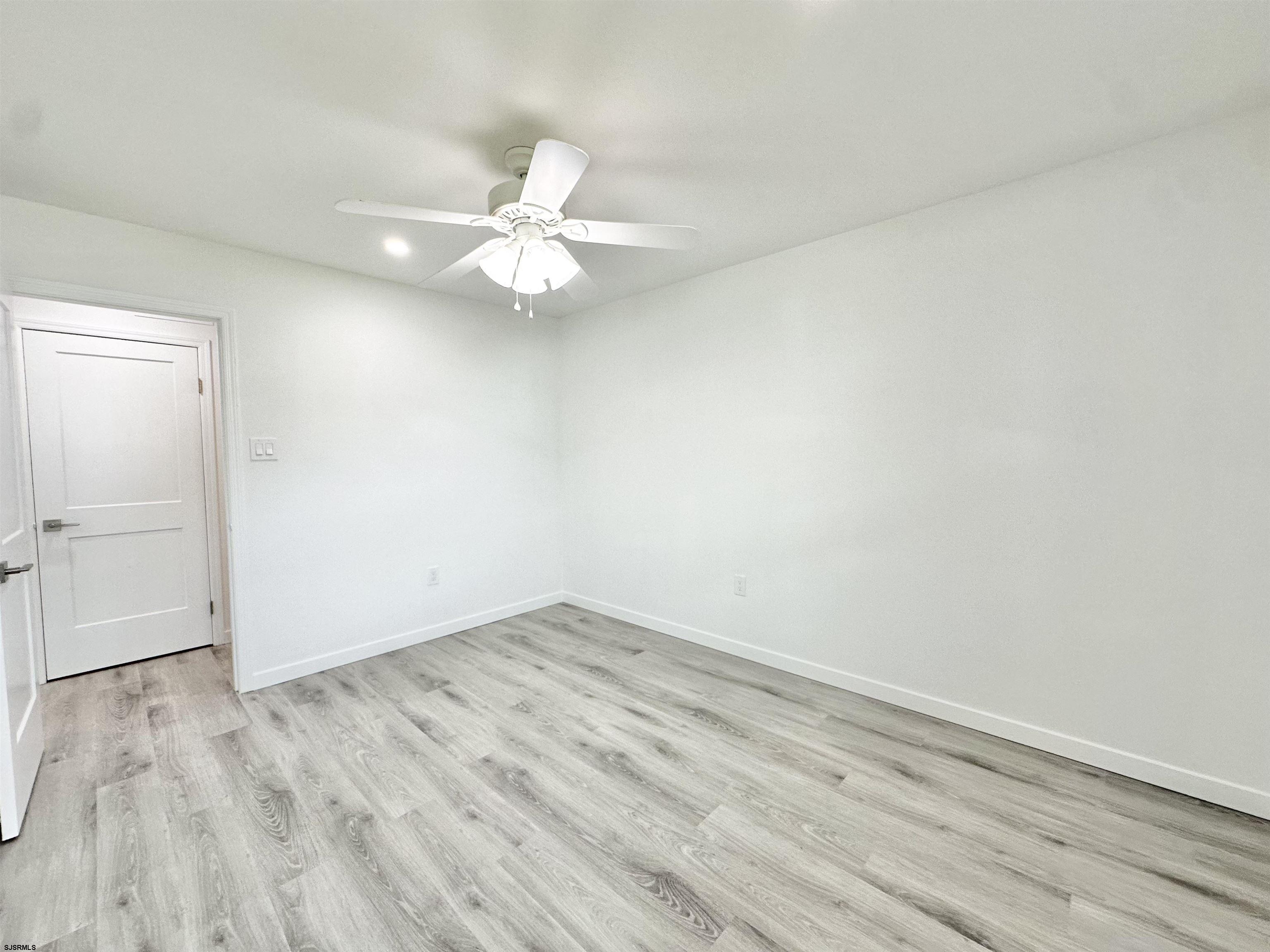 340 Seashell Lane Brigantine, NJ 08203 - Photo 27 of 47 an empty room with wooden floor and fan