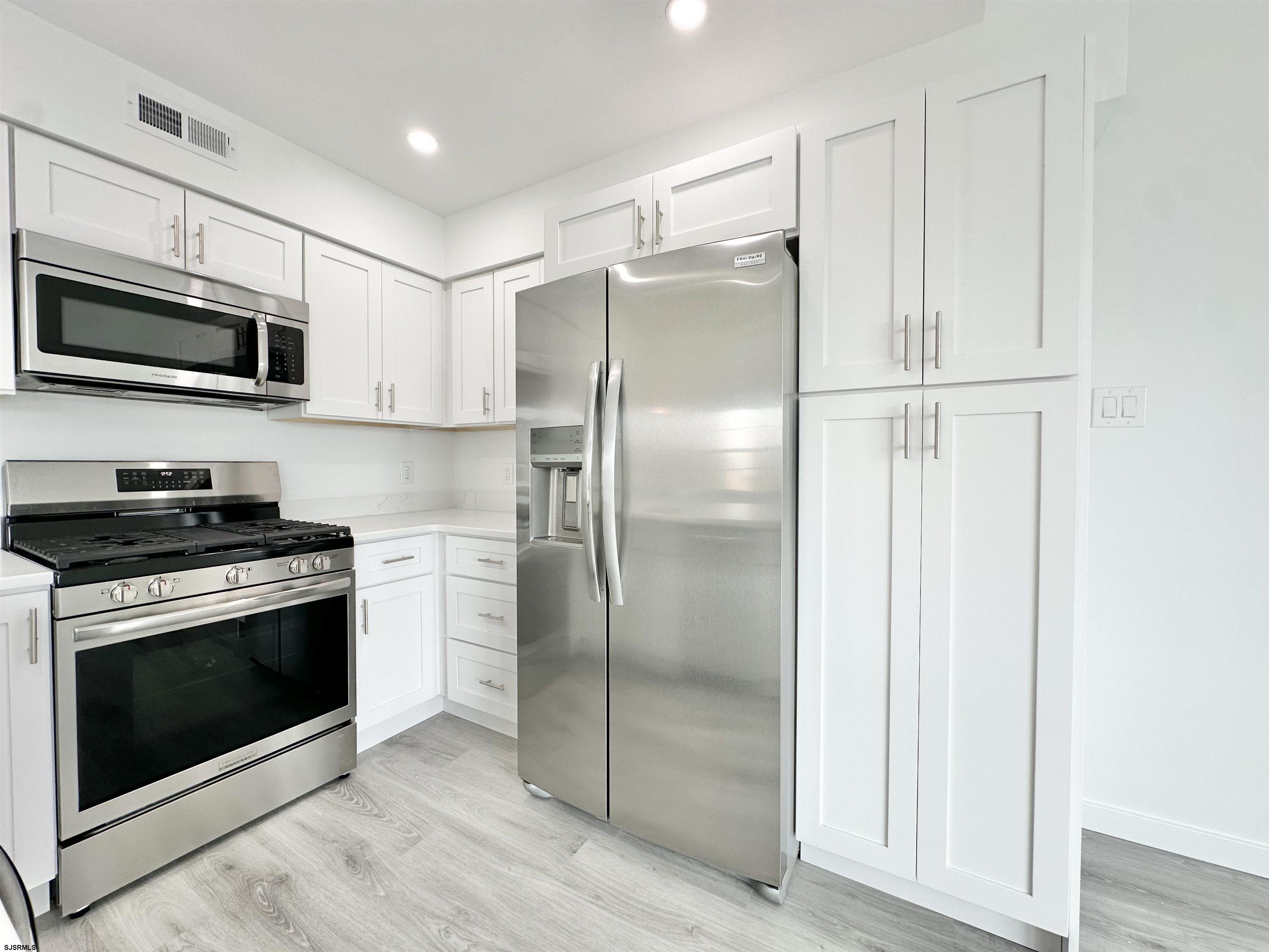 340 Seashell Lane Brigantine, NJ 08203 - Photo 6 of 47 a metallic refrigerator freezer and a stove sitting inside of a kitchen