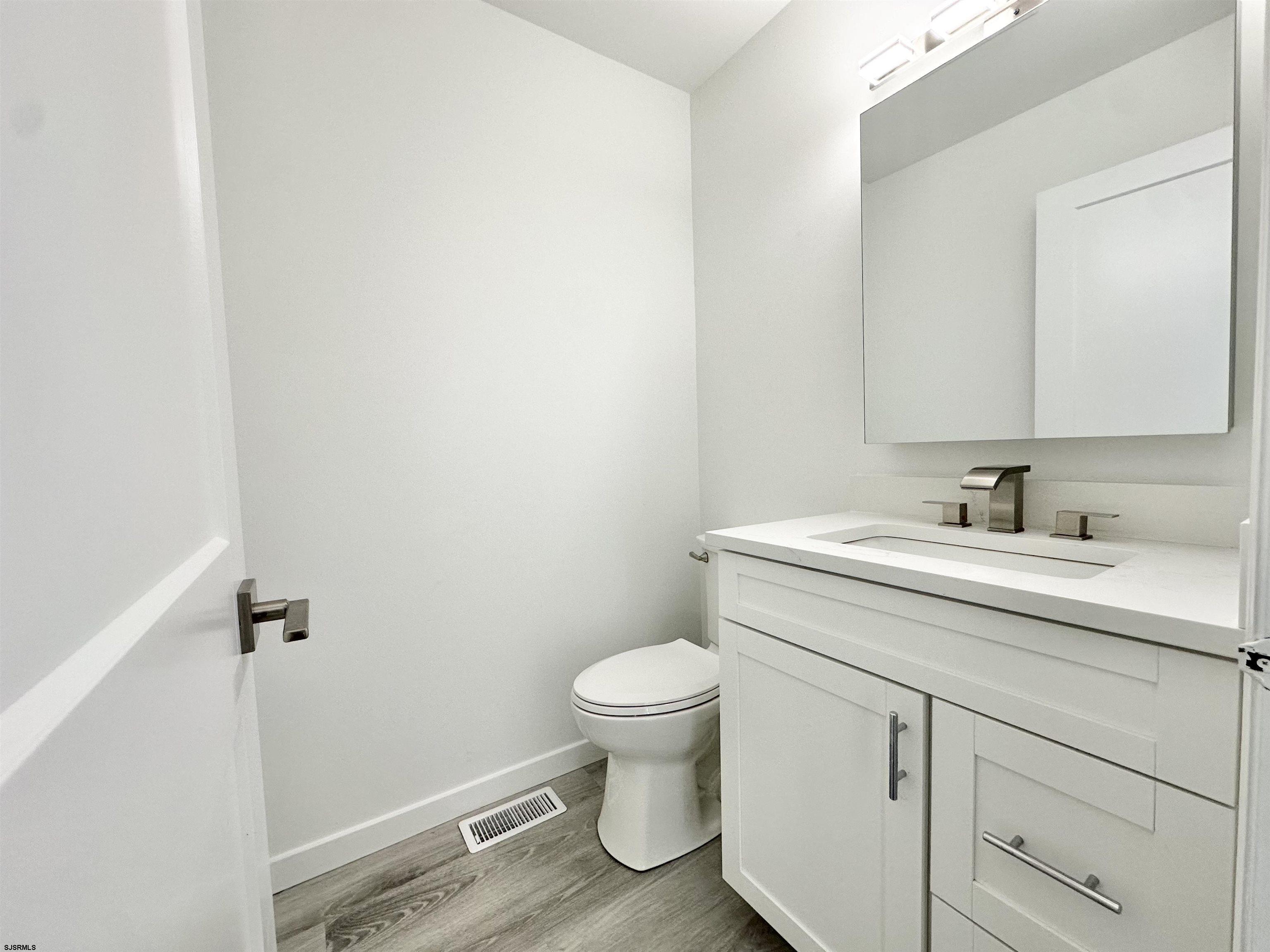 340 Seashell Lane Brigantine, NJ 08203 - Photo 9 of 47 a bathroom with a granite countertop sink a toilet and a mirror