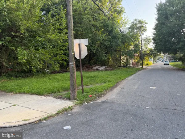 a street sign on a sidewalk next to a road