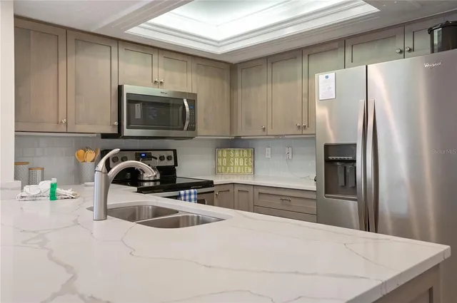 a kitchen with stainless steel appliances granite countertop a refrigerator sink and microwave