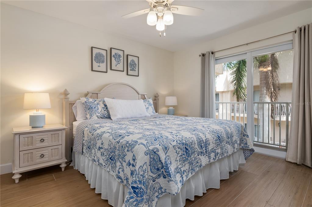 5963 Midnight Pass Road, Unit 332 Sarasota, FL 34242 - Photo 17 of 49 a bedroom with a large bed and a chandelier