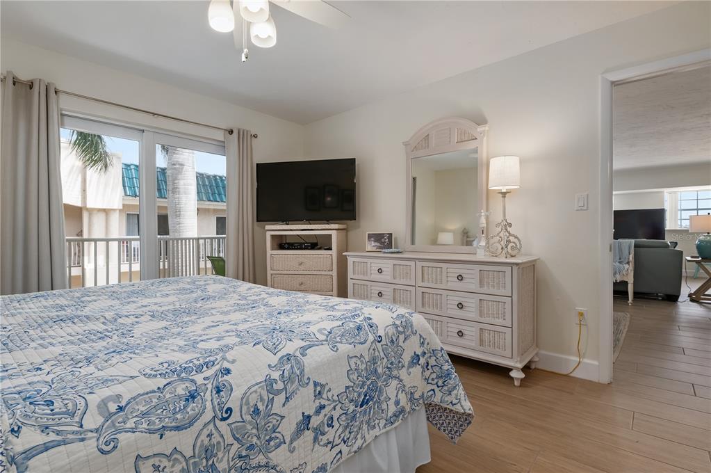 5963 Midnight Pass Road, Unit 332 Sarasota, FL 34242 - Photo 18 of 49 a bedroom with a bed and a flat screen tv