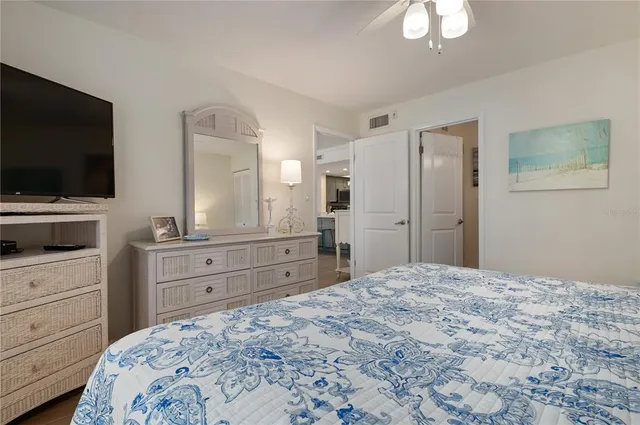 a bedroom with a bed and a flat screen tv in white dresser