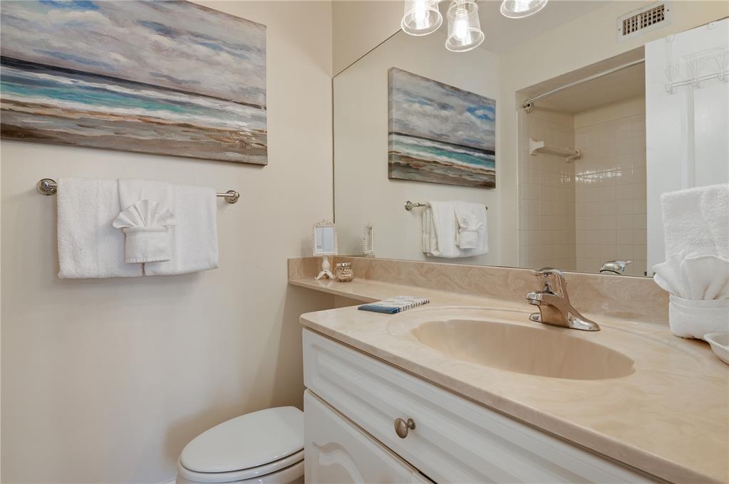 5963 Midnight Pass Road, Unit 332 Sarasota, FL 34242 - Photo 20 of 49 a bathroom with a granite countertop toilet sink and mirror