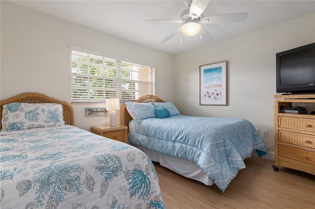 5963 Midnight Pass Road, Unit 332 Sarasota, FL 34242 - Photo 21 of 49 a bedroom with two beds and a chandelier