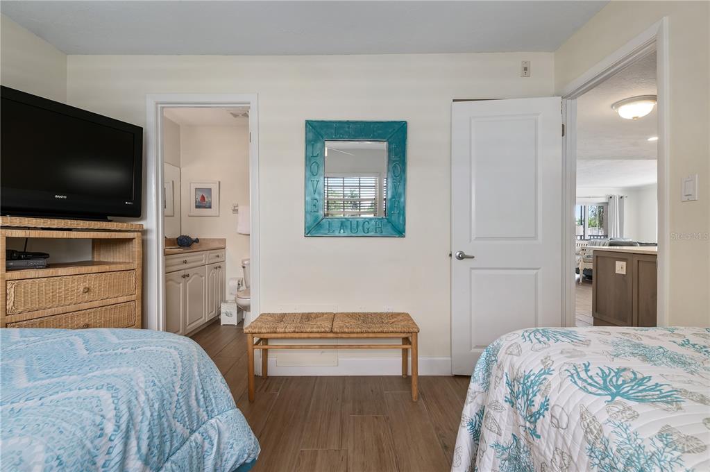 5963 Midnight Pass Road, Unit 332 Sarasota, FL 34242 - Photo 22 of 49 a bedroom with a bed and a flat screen tv