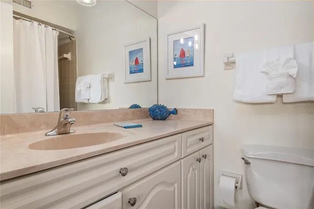 a bathroom with a granite countertop sink a toilet and a mirror