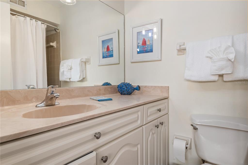 5963 Midnight Pass Road, Unit 332 Sarasota, FL 34242 - Photo 23 of 49 a bathroom with a granite countertop sink a toilet and a mirror