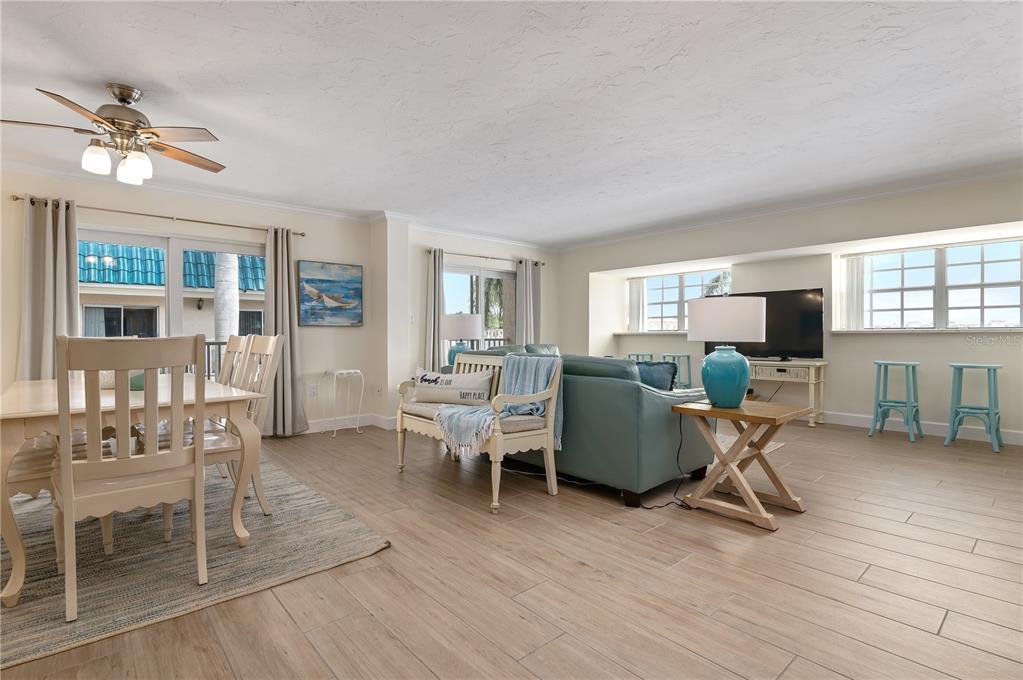 5963 Midnight Pass Road, Unit 332 Sarasota, FL 34242 - Photo 6 of 49 a living room with furniture a flat screen tv and a table