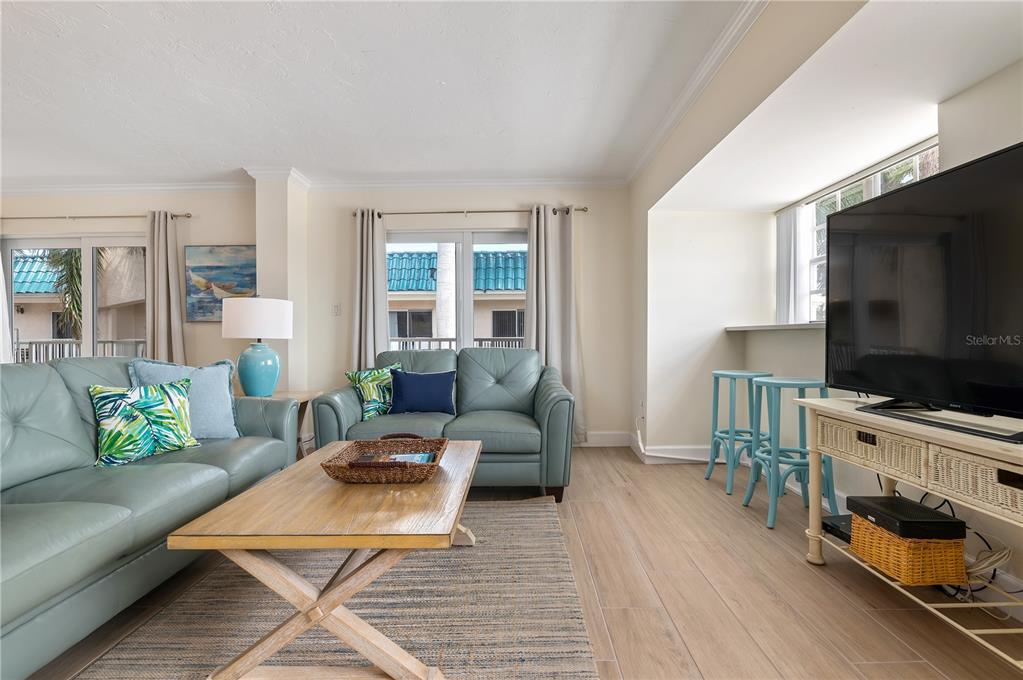 5963 Midnight Pass Road, Unit 332 Sarasota, FL 34242 - Photo 8 of 49 a living room with furniture and a flat screen tv