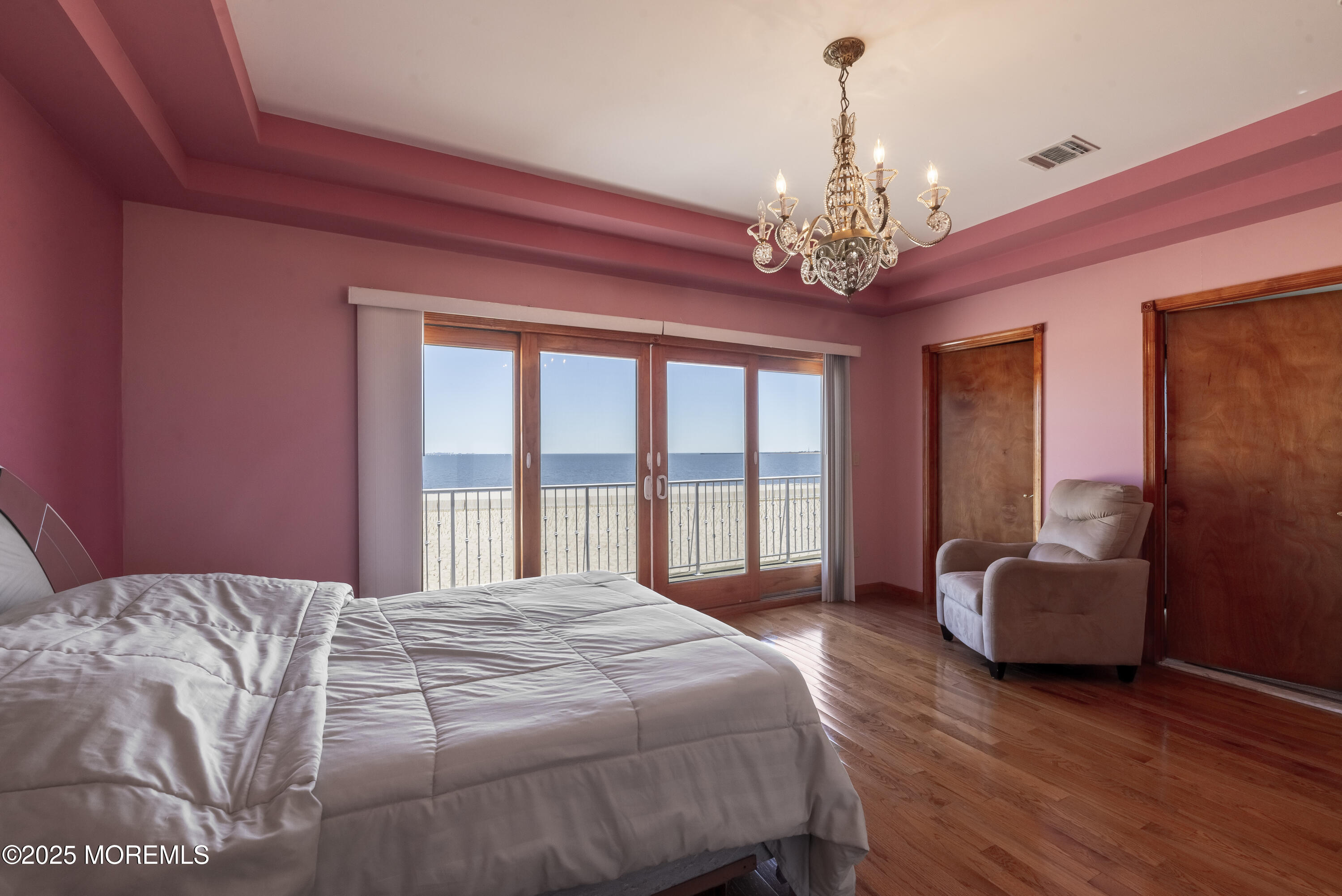 329 Front Street Union Beach, NJ 07735 - Photo 15 of 51 a spacious bedroom with a large bed and a chandelier