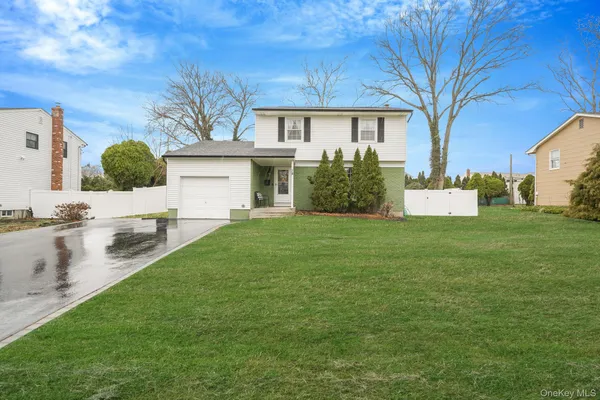 a view of an house with backyard and a tree