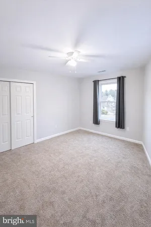 an empty room with chandelier fan
