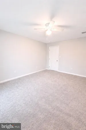an empty room with a ceiling fan and a window