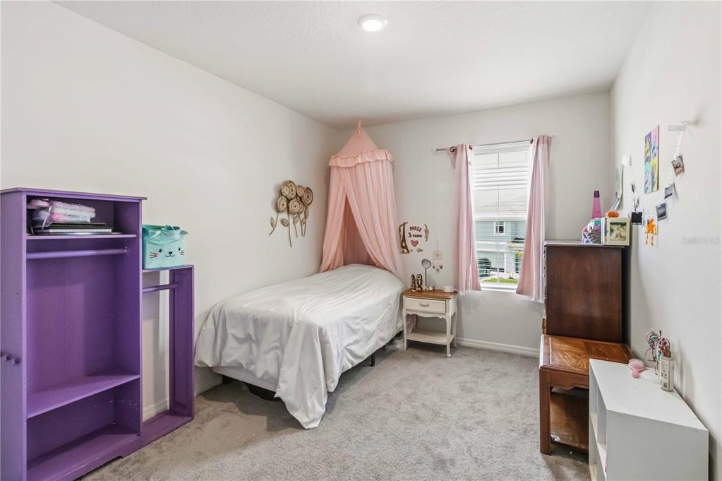 8354 Hardy Bay Loop Wesley Chapel, FL 33545 - Photo 17 of 32 a bedroom with a bed and a desk