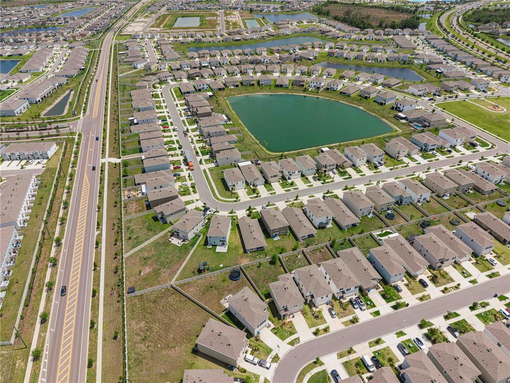 8354 Hardy Bay Loop Wesley Chapel, FL 33545 - Photo 29 of 32 an aerial view of a residential apartment building with a yard