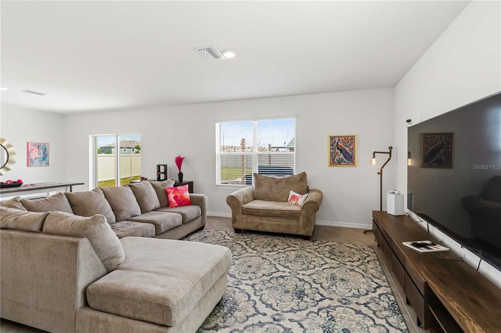 8354 Hardy Bay Loop Wesley Chapel, FL 33545 - Photo 3 of 32 a living room with furniture and a flat screen tv