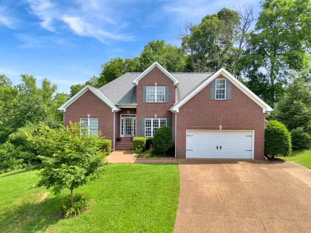 a front view of a house with a yard and garage