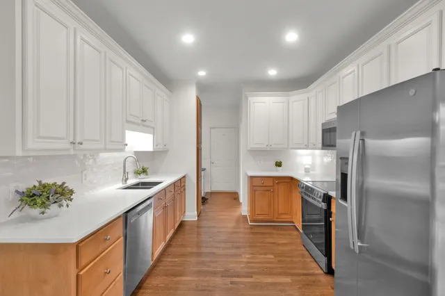 a kitchen with granite countertop a refrigerator and a sink