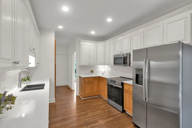 a kitchen with stainless steel appliances granite countertop a refrigerator and a stove
