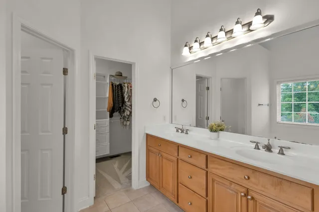 a bathroom with double vanity sinks a vanity a mirror and a shower