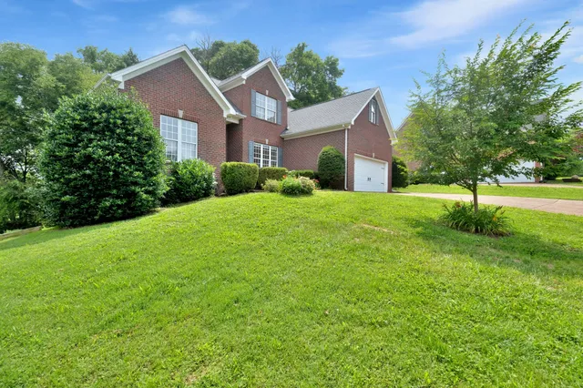 a front view of a house with a yard and garage