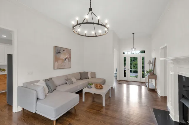 a living room with fireplace furniture and a chandelier