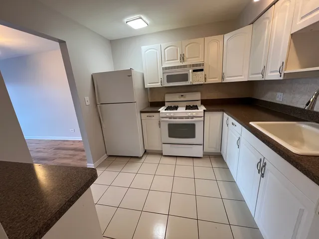 a kitchen with a sink a stove a microwave and cabinets