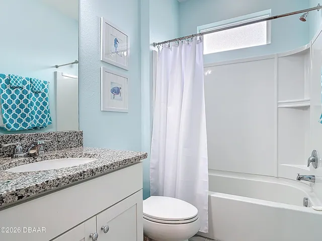 a bathroom with a granite countertop sink a toilet and shower