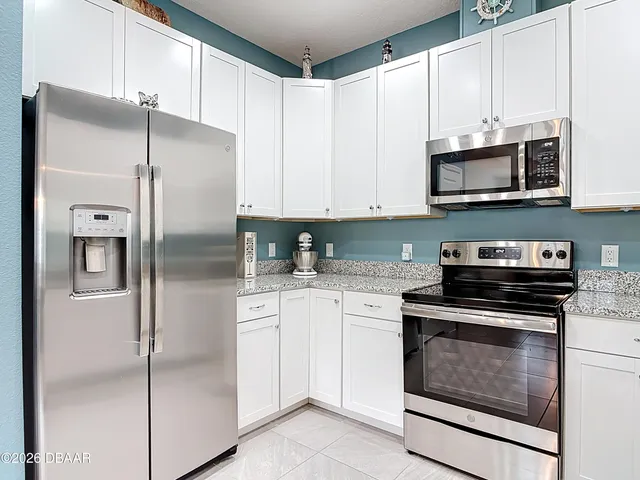 a kitchen with stainless steel appliances granite countertop a refrigerator and a stove