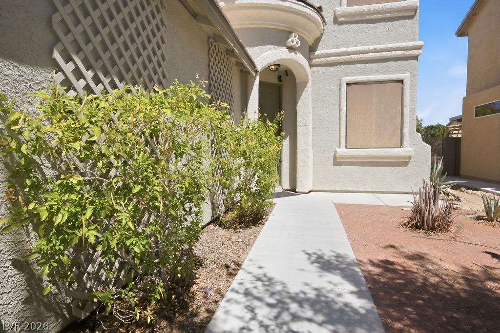 9712 North Running Rabbit Street Las Vegas, NV 89143 - Photo 10 of 42 A welcoming walkway leads to a charming stucco exterior with distinctive architectural details.
