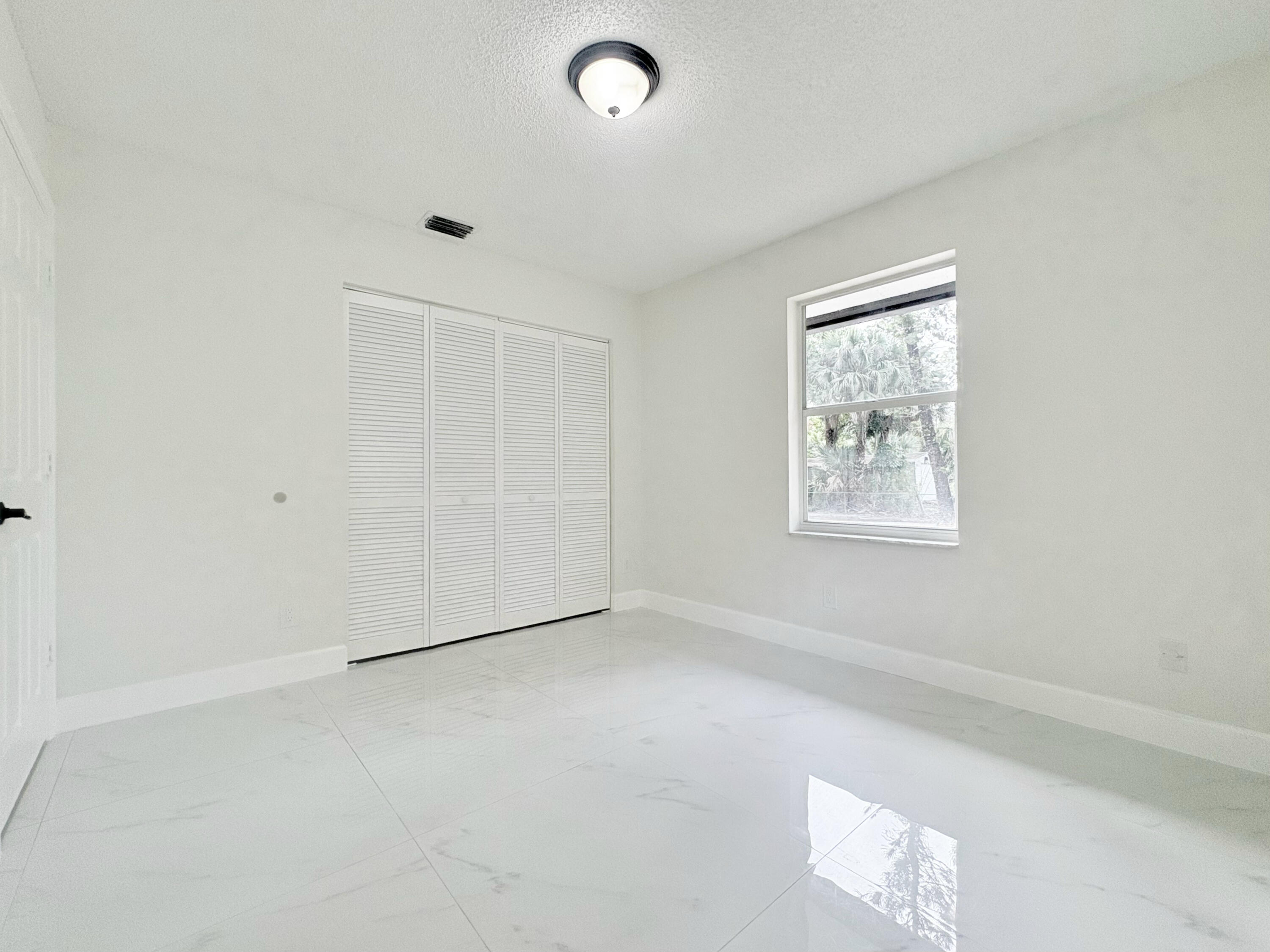 14523 Flamingo Road Loxahatchee Groves, FL 33470 - Photo 10 of 50 an empty room with windows