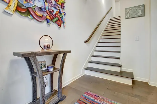 a view of a hallway with wooden floor and staircase