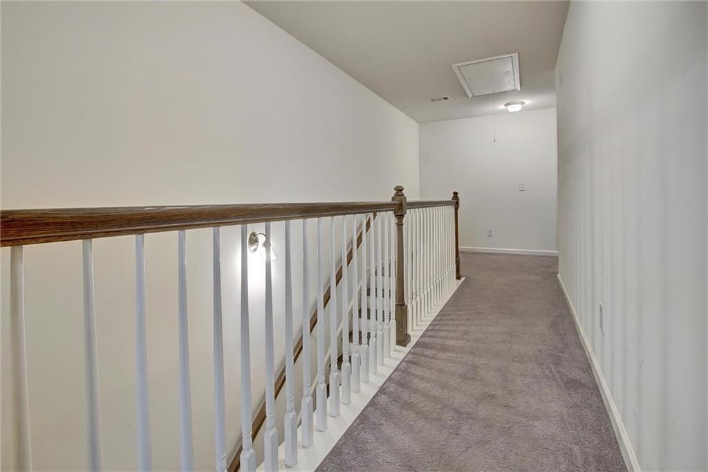 7687 Cabrini Place Fairburn, GA 30213 - Photo 13 of 29 a view of a hallway with wooden floor and staircase