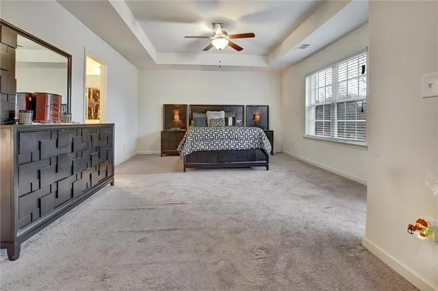 a spacious bedroom with a bed and a chandelier