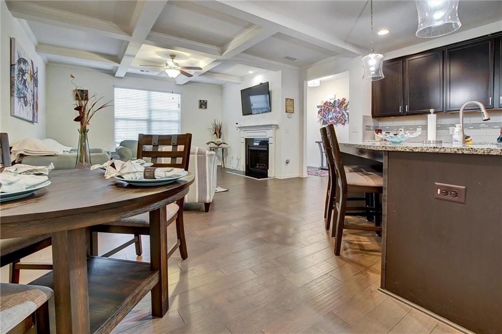 7687 Cabrini Place Fairburn, GA 30213 - Photo 4 of 29 a kitchen with a table chairs microwave and cabinets