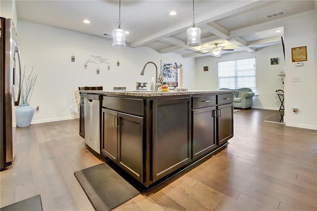 7687 Cabrini Place Fairburn, GA 30213 - Photo 6 of 29 a kitchen with stainless steel appliances granite countertop a stove a sink dishwasher and a refrigerator with wooden floor